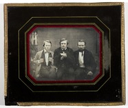 Miniaturansicht Vorschau von Gruppeportrett av tre menn sittende utendørs.…