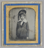 Thumbnail af Portrait of a boy standing in front of a door…