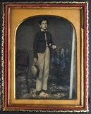 Esikatselunkuvan Boy, full length, standing near table covered… näyttö
