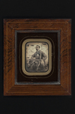 Thumbnail preview of portrait of a hunter, sitting in front of a c…