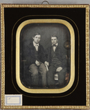 Thumbnail preview of Zwei junge Männer, sitzend, einer hält ein Bu…
