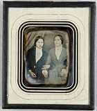 Thumbnail af Zwei Frauen sitzend, eine hakt sich bei der a…