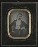 Prévisualisation de Man with beard resting his arm on wooden tabl… imagettes