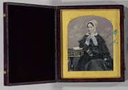 Stručný náhled Portrait of a seated older woman wearing a da…