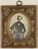 Thumbnail af Portrait of a man, seated, holding a stick.