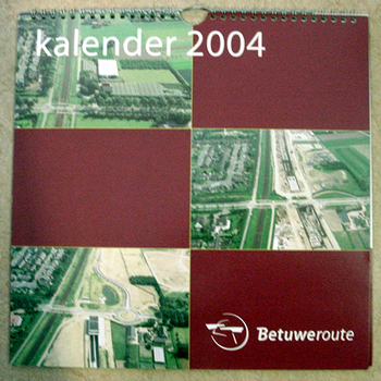Kalender van papier van het jaar 2004 met luchtfoto's van de aanleg van de Betuwelijn te Zevenaar 2003