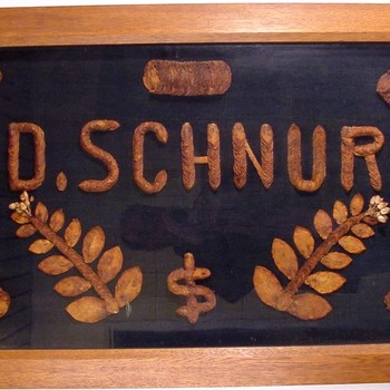 Een collage in houten lijst gemaakt van gedroogde tabaksbladeren gewijd aan David Schnur ca. 1938-1948