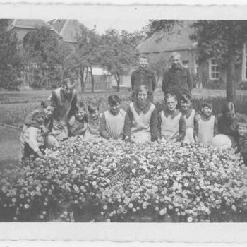 Foto, voorstellende weeskinderen met moeder Bosch in de tuin van het Elisabeth Weeshuis te Culemborg, 1936