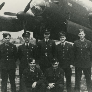 Foto van zeven man in R.A.F. uniform voor Avro Lancaster bommenwerper. Tekst achterop: "Crew Lancaster OF-K (97 Sqdn.) P.F.F.". Tekst er onder: "Lancaster met crew van het 97e Pathfinder Squadron OF-K 1944".