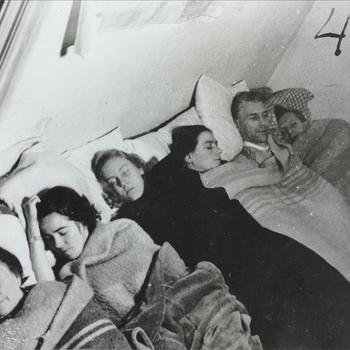 zes personen onder de dekens in een schuilkelder