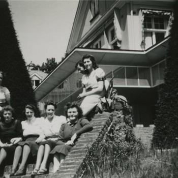 6 jonge vrouwen aan achterkant van een gebouw (Dekkerswald)