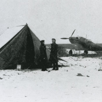 Foto van twee R.A.F. soldaten voor een tent in een besneeuwd veld. Op achtergrond twee Fairey Battle vliegtuigen.
