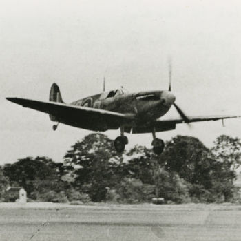Foto van landende Supermarine Spitfire. Tekst achterop: "Spitfire in landing. Foto: Spitfire, the story of a famous fighter, blz 57".