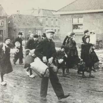 Foto evacuatie zeeuwse inwoners. Huizen op de achtergrond. Tekst achterop: "Zeeland: evacuatie 1944".