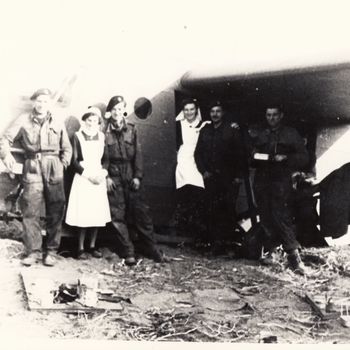 Foto van een Waco CG-4 glider en tank met Canadese soldaten en verpleegsters