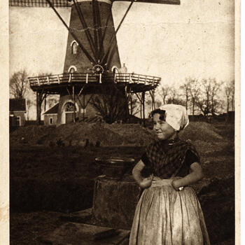 Meisje in Zuid-Bevelandse streekdracht bij molen, 1905–1922