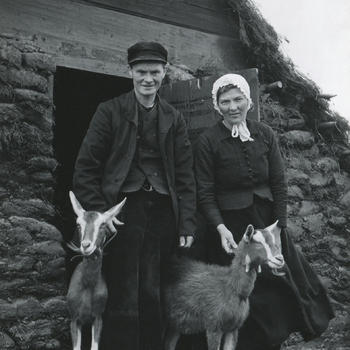 Drentse man en vrouw voor een plaggenhut in openluchtmuseum Schoonoord, 1954