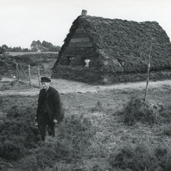 Man bij plaggenhut in openluchtmuseum Schoonoord, 1954