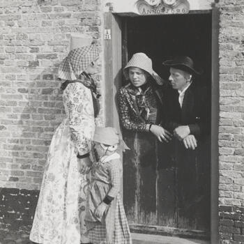 Vrouw, meisjes en man, verkleed in Hindelooper dracht, 1944