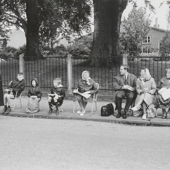 Bezoekers van het Oogst-fruitcorso hebben hun eigen stoelen meegenomen om de corso zittend te kunnen aanschouwen. De foto is genomen in de Heiligestraat, op de achtergrond de L.T.S