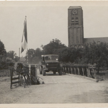 Brug over Linge bij Zoelen. Waarschijnlijk bij de bevrijding rijdt een vrachtwagen van de geallieerden over de brug bij Zoelen. Op de achtergrond rechts de kerk van Zoelen