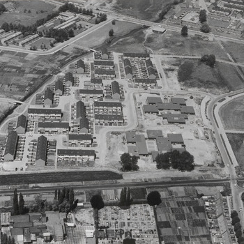 Luchtfoto van Tiel. Nieuwbouw in Groenendaal-Westroyen, omstreeks oktober 1976. Geheel rechts de Gemeentelijke begraafplaats. Links de Dode Linge. Rechts bovenaan "De Hennepe". In het midden het scholencomplex