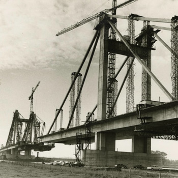 De Prins Willem Alexanderbrug is in aanbouw. Met de bouw van deze brug is de combinatie Tielse brug, de aannemersbedrijven Zanen Veerstoep en Van Hattum en Blankenvoort in november 1970 begonnen. Op de foto nadert de brug haar voltooiing