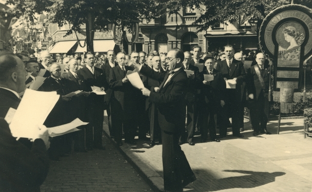 658882 - Koren. Muziek. Feestelijkheden rondom het 75 jarige jubileum van het Koninklijk Tilburgs Mannenkoor St. Caecilia op waarschijnlijk 12 oktober 1952. Optreden van het koor onder leiding van dirigent D.W. van Leeuwen.